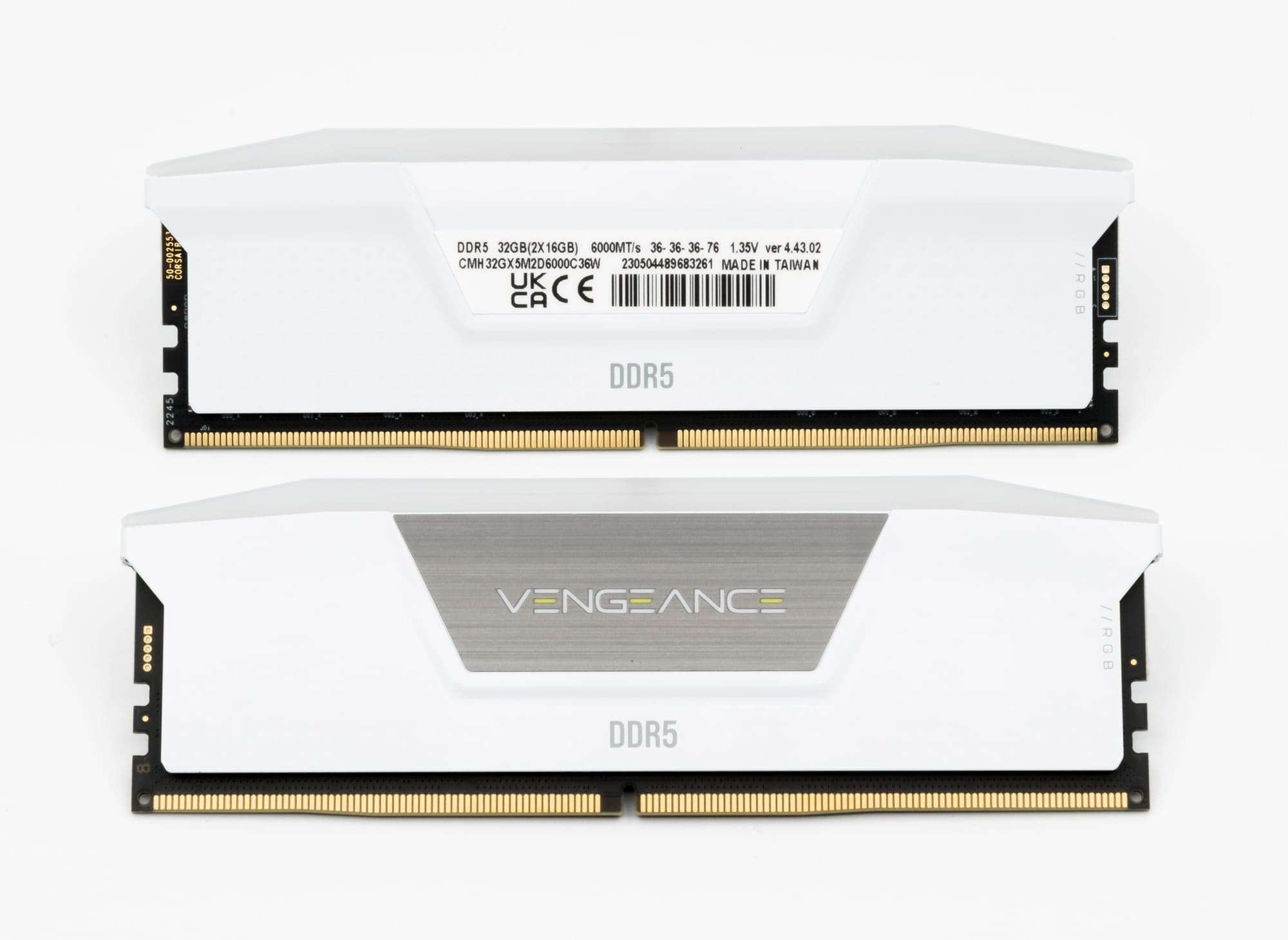 Deux barrettes de mémoire DDR5 Corsair Vengeance RGB blanches formant un kit de 32 Go, l'une côté étiquette, l'autre côté logo, sur fond blanc